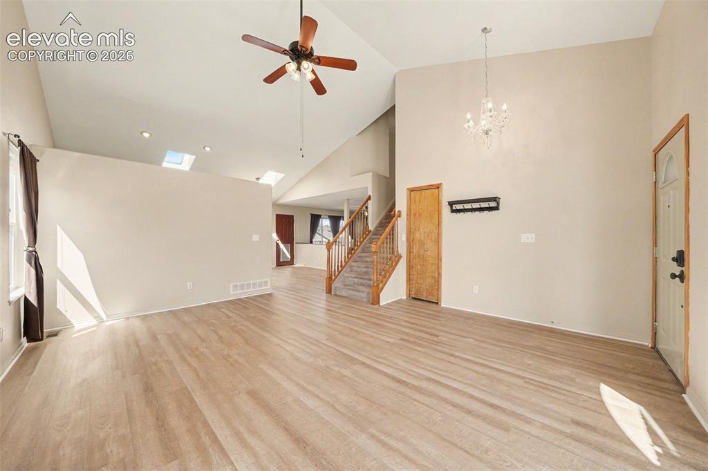 Image 3 of 23: Vaulted ceilings, skylights, recessed lighting, wood-finish flooring, and a