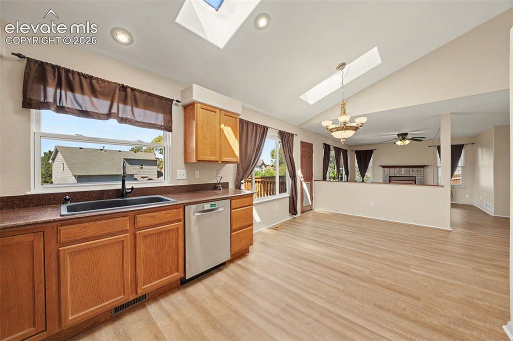 Image 7 of 23: Kitchen featuring wood-finish flooring, oak cabinetry, stainless steel dish