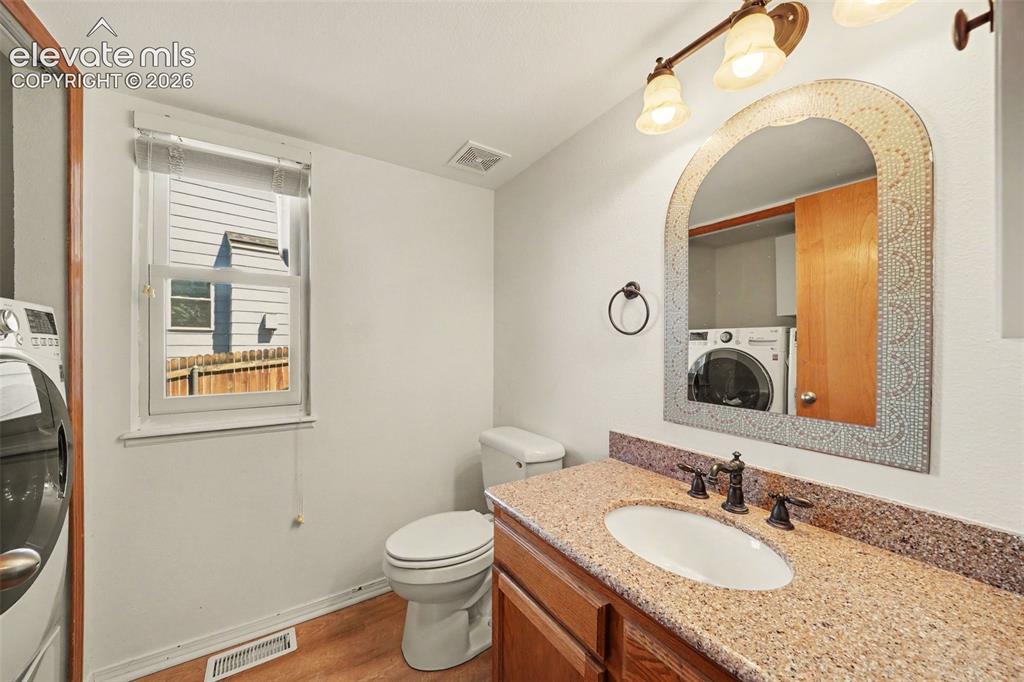 Image 9 of 23: Bathroom featuring a window, wood-finish flooring, a vanity with an integra
