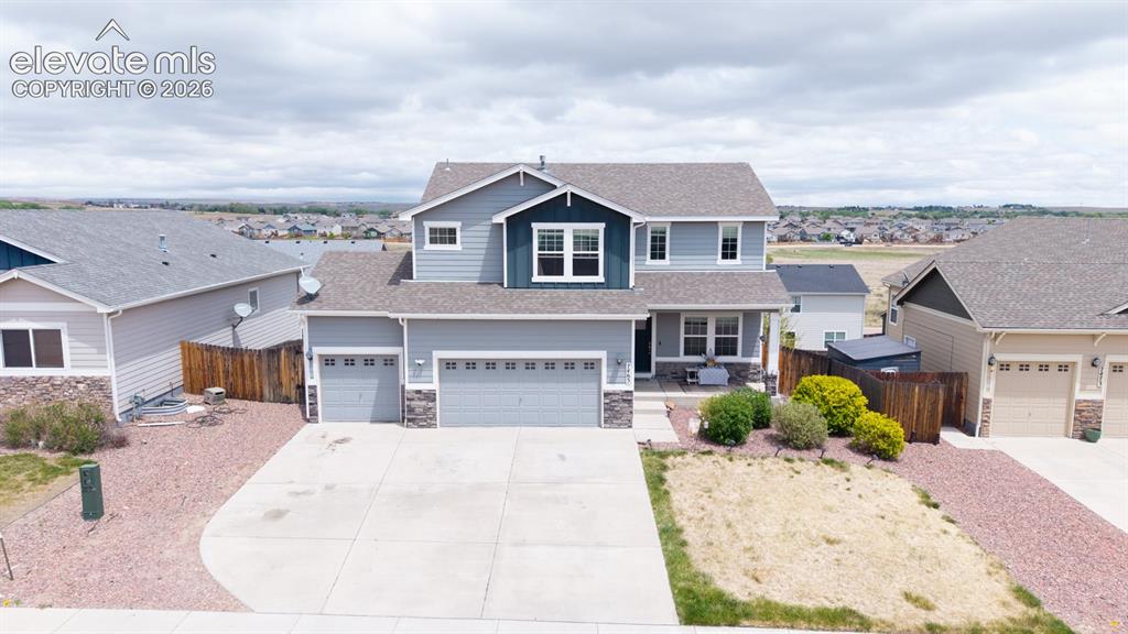 Image 11 of 44: Two-story residence with a gray siding exterior and dark blue accent siding