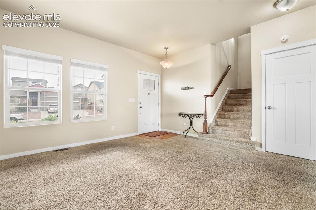 Image 17 of 44: Entry foyer featuring a front door with an integrated glass panel, two larg