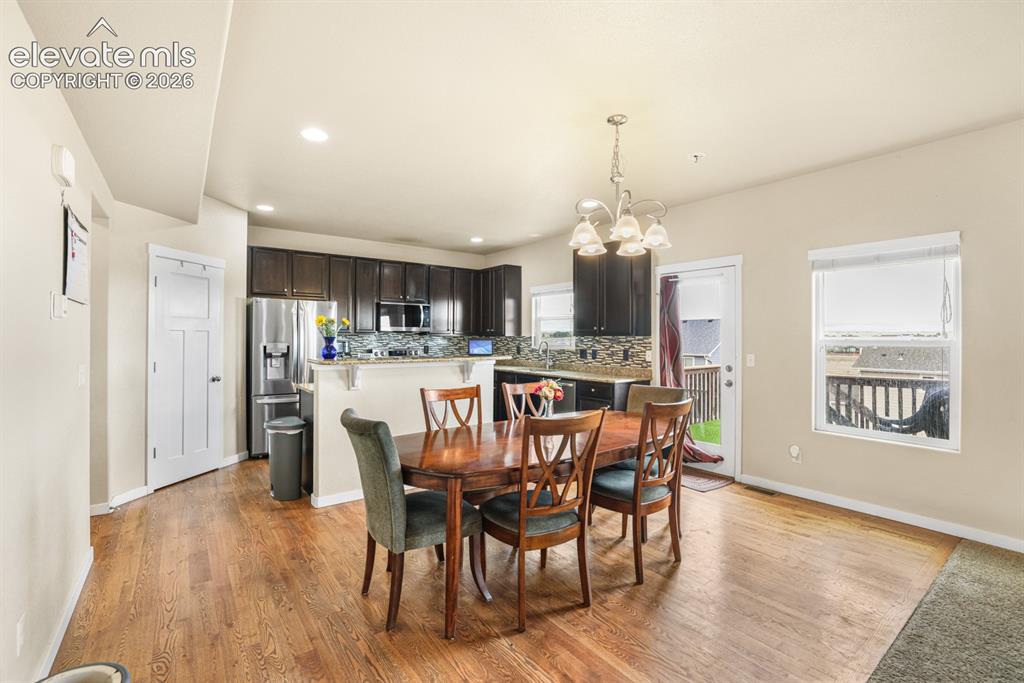 Image 18 of 44: Open-concept living space featuring wood-finish flooring, dark cabinetry, s