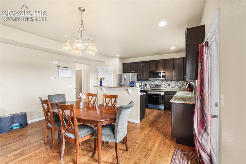 Image 19 of 44: Open-concept kitchen and dining area with wood-finish flooring