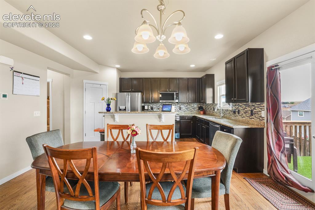 Image 21 of 44: Kitchen and dining area featuring wood-finish flooring