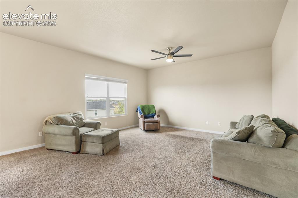 Image 23 of 44: Spacious room with vaulted ceilings and neutral-toned carpet