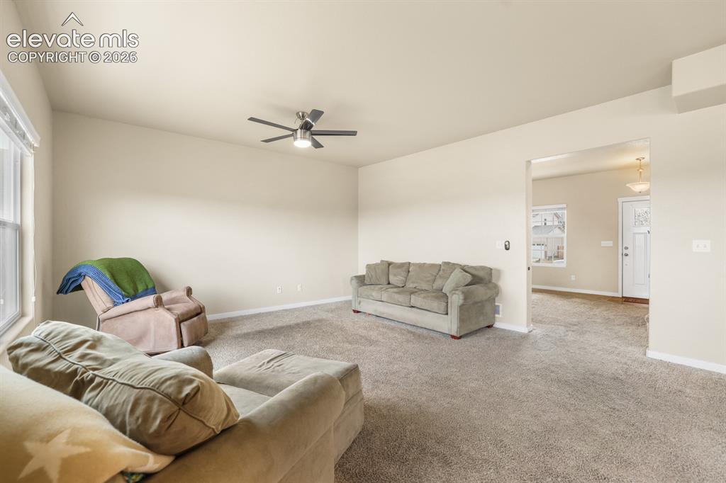 Image 24 of 44: Spacious living room featuring vaulted ceilings and a ceiling fan