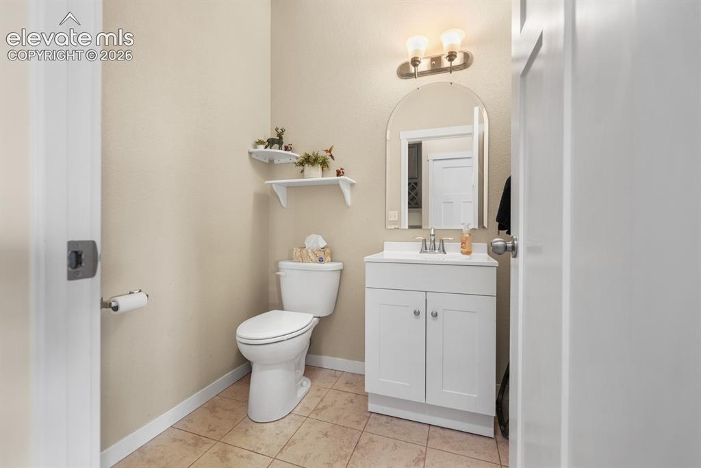Image 25 of 44: Bathroom featuring a white vanity with an integrated sink, an arched mirror