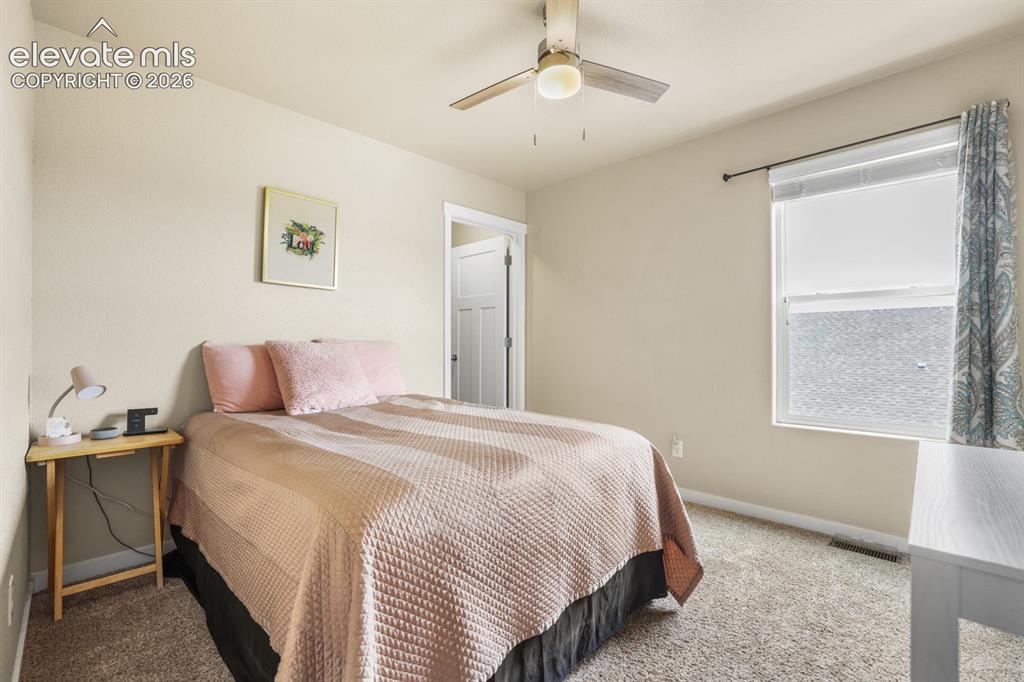 Image 28 of 44: Bedroom featuring neutral-toned walls, carpeted flooring, and a ceiling fan