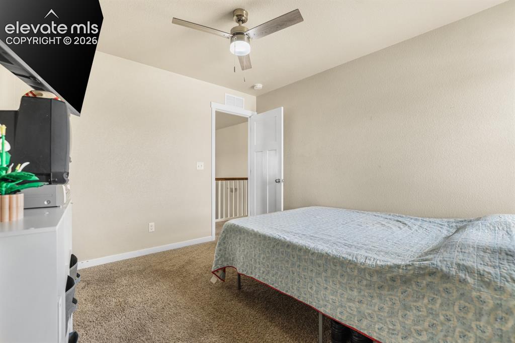 Image 31 of 44: Carpeted room featuring a ceiling fan with light fixture, neutral-toned wal