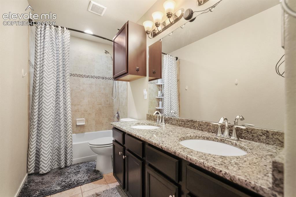 Image 32 of 44: Bathroom featuring a double vanity with granite countertop and dual undermo