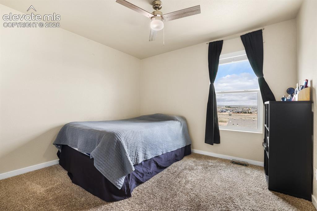 Image 33 of 44: Bedroom featuring neutral-toned walls, carpet flooring, and a ceiling fan