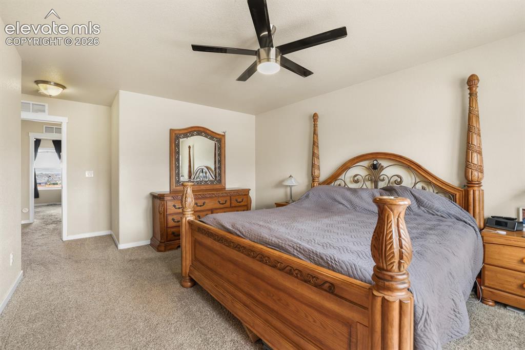 Image 38 of 44: Carpeted bedroom featuring a ceiling fan with integrated lighting, recessed
