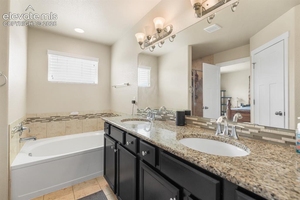 Image 39 of 44: Bathroom featuring a double vanity with granite countertops, undermount sin