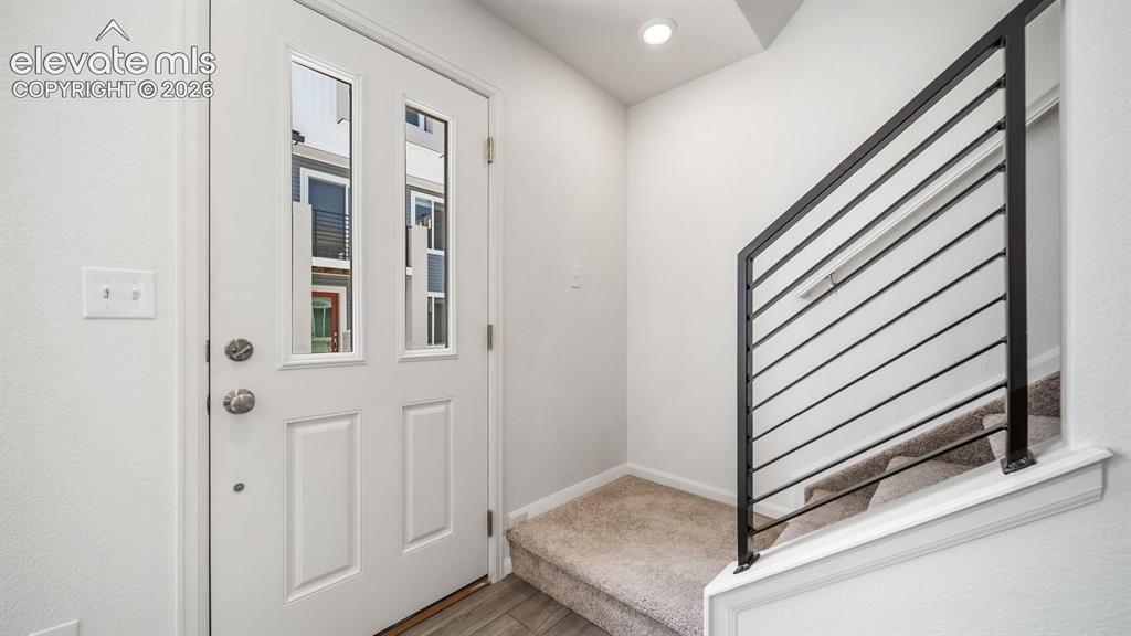 Image 2 of 24: Entryway featuring a paneled door with dual glass inserts, brushed nickel h
