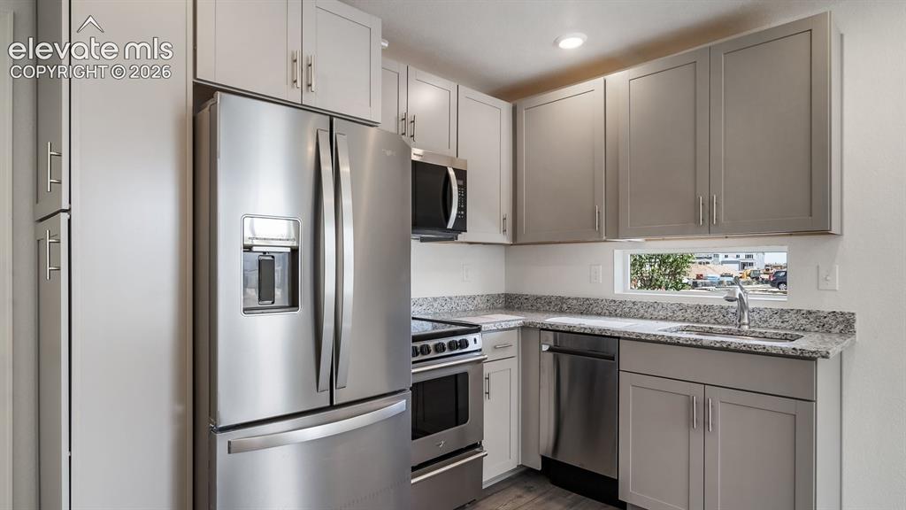 Image 5 of 24: Modern kitchen featuring stainless steel appliances, granite countertops, g