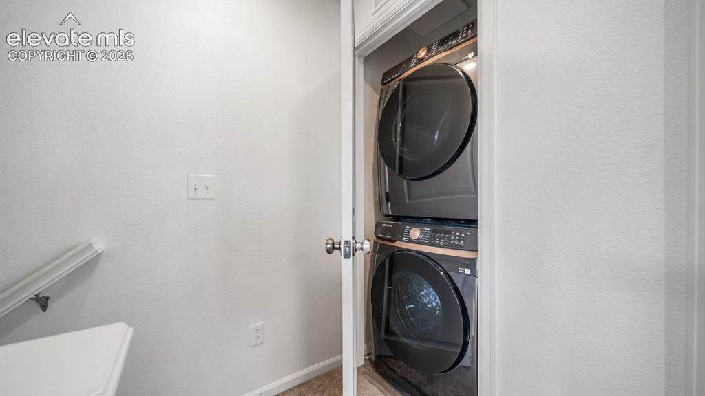 Image 7 of 24: Dedicated laundry closet featuring a stacked washer and dryer unit
*Photos
