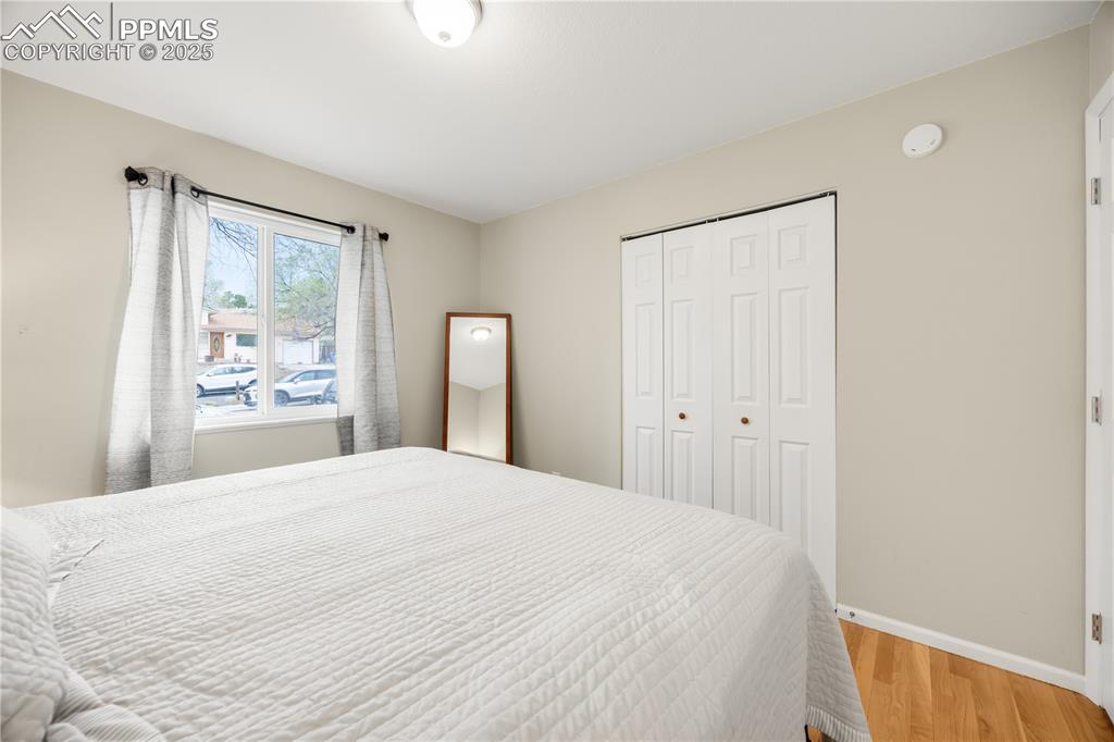 Image 25 of 36: Bedroom with baseboards, a closet, and light wood-style flooring