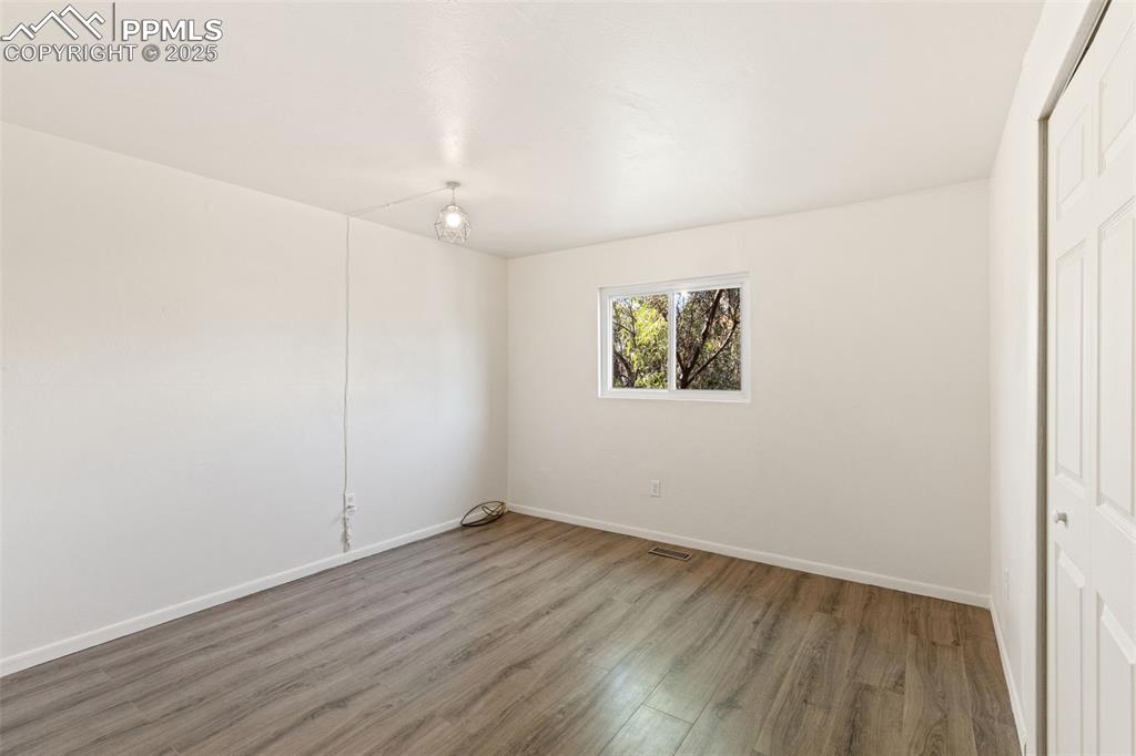 Image 31 of 44: Unfurnished bedroom with wood finished floors and a closet