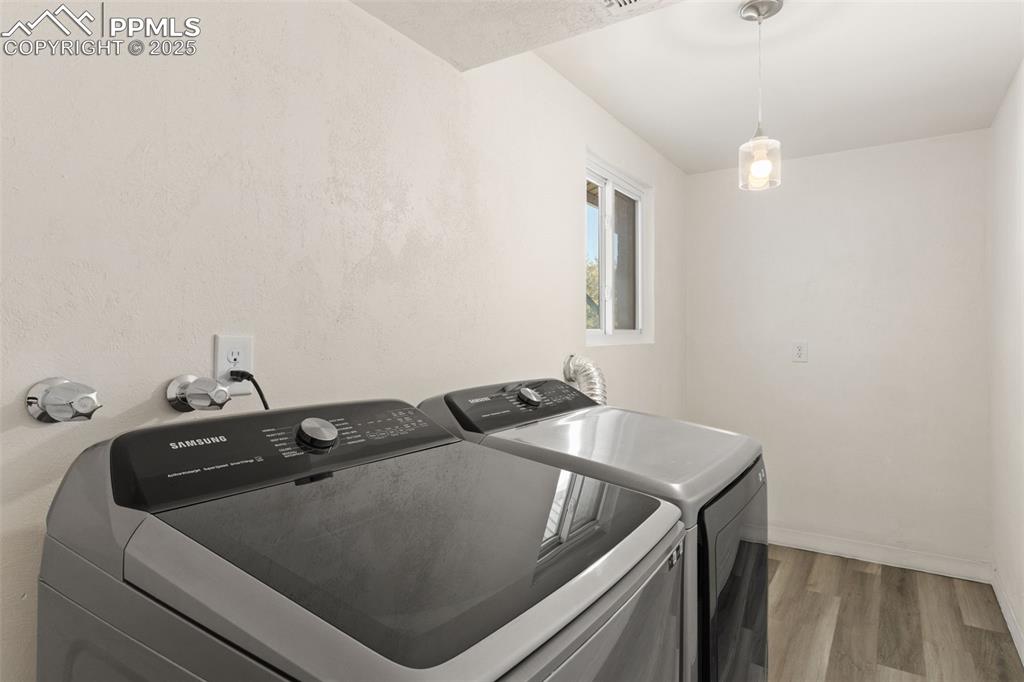 Image 34 of 44: Laundry room featuring wood finished floors and washer and dryer