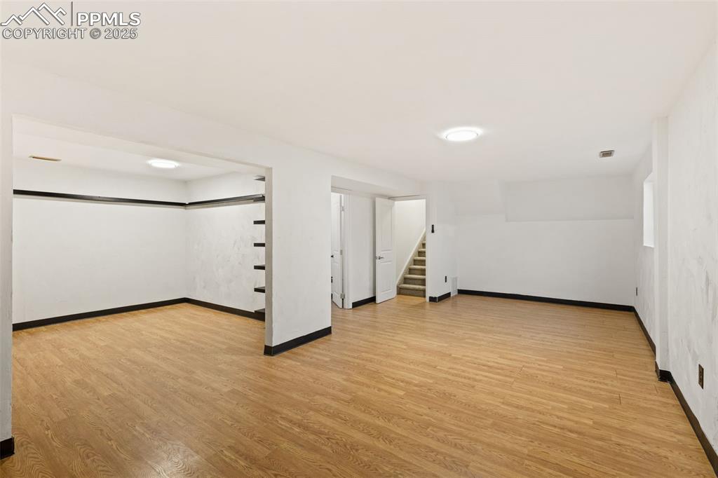 Image 36 of 44: Finished basement with light wood-type flooring and stairway