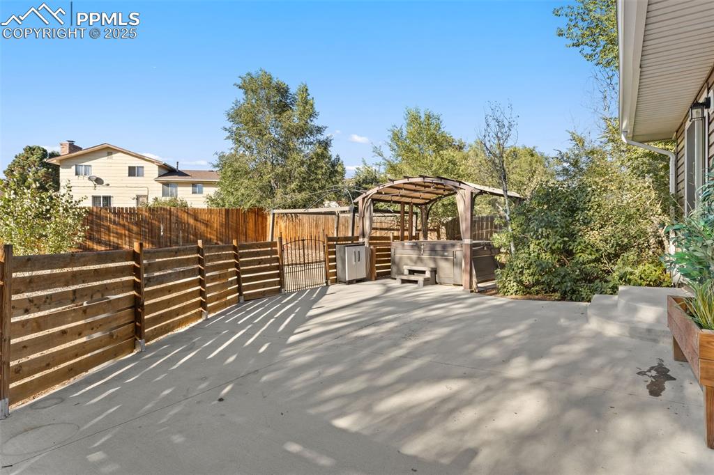 Image 40 of 44: Fenced backyard featuring a patio area, a hot tub, and a pergola