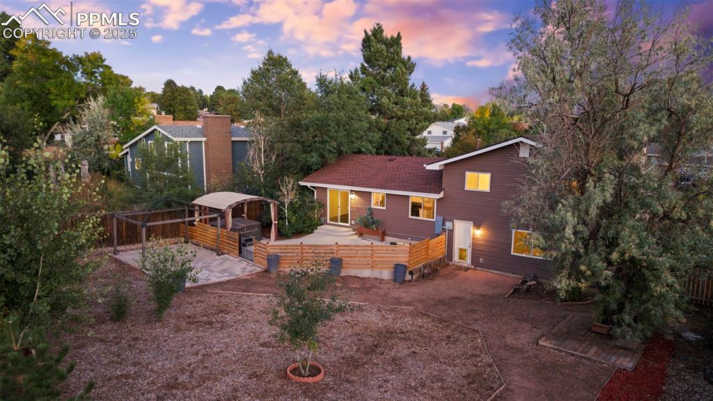 Image 7 of 44: Back of property at dusk featuring a patio, a fenced backyard, and a shingl