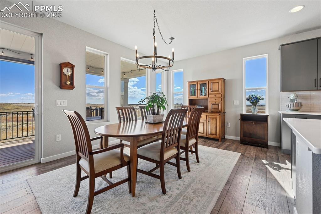 Image 12 of 49: Dining area with hanging lights, dark wood-style floors, and healthy amount