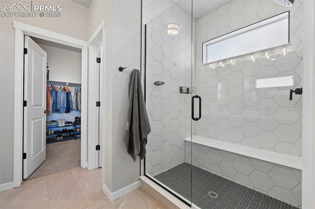 Image 23 of 49: Primary bath featuring a spacious closet and a shower stall
