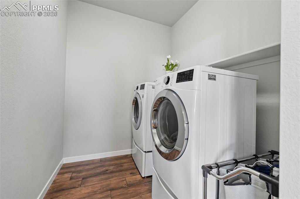 Image 25 of 49: Main Level Laundry area featuring dark wood-style floors, washer and dryer,