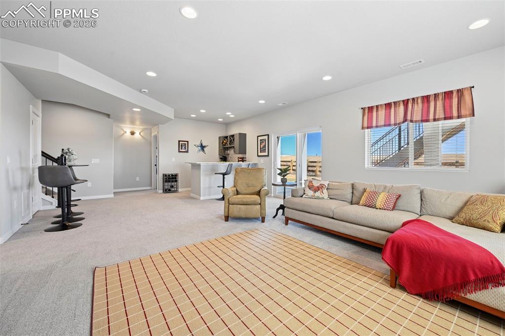 Image 31 of 49: Basement family room featuring light carpet and recessed lighting