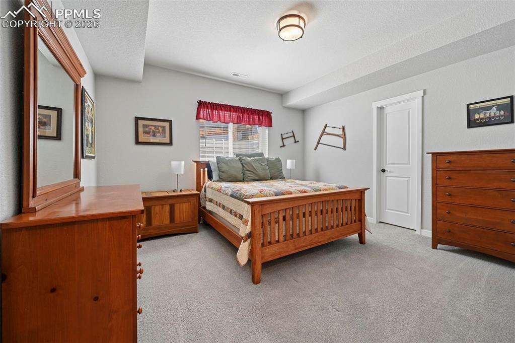 Image 35 of 49: 3rd Bedroom - Basement - Bedroom featuring light carpet and a textured ceil