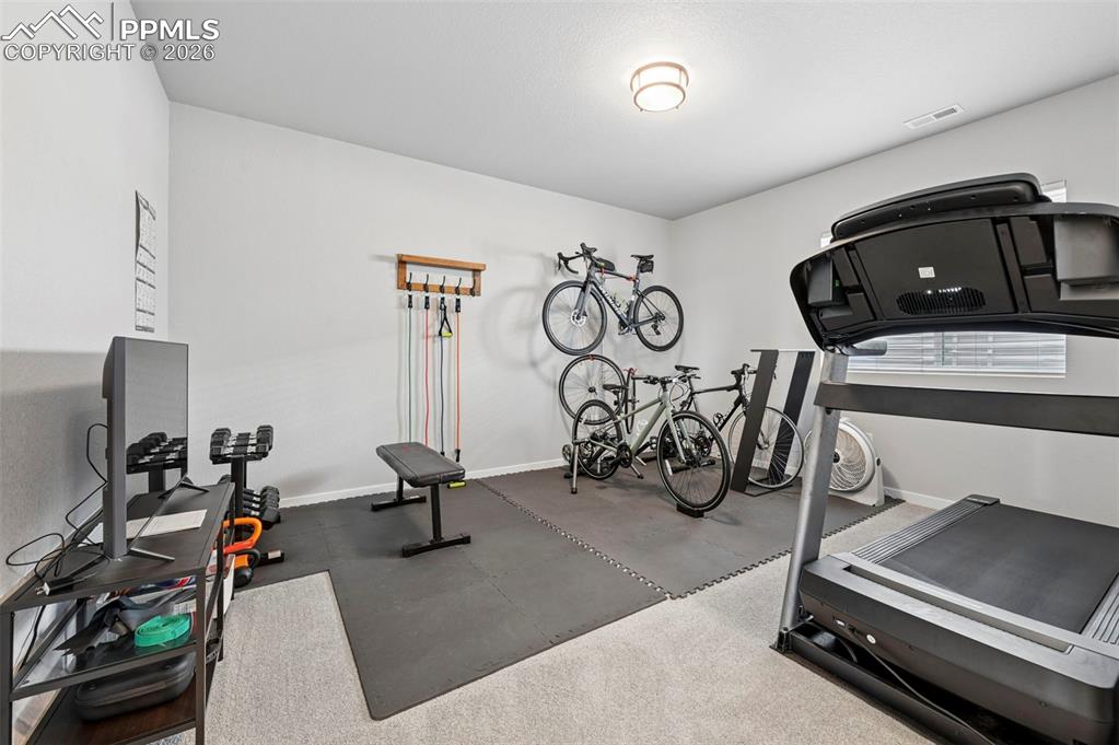 Image 40 of 49: 5th Bedroom - Exercise area featuring rubber floors and baseboards