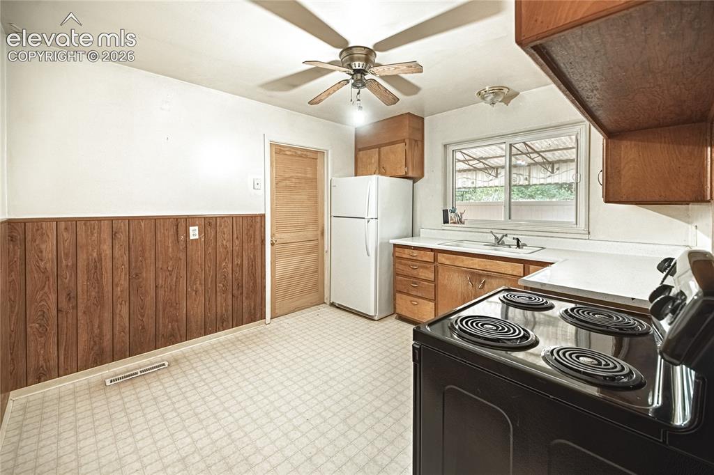 Image 10 of 44: Kitchen featuring wood-finish cabinetry, white countertops, built-in range,