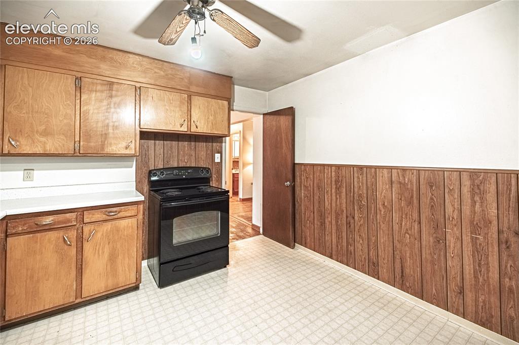 Image 13 of 44: Kitchen featuring wood cabinetry, white countertops, a black electric range