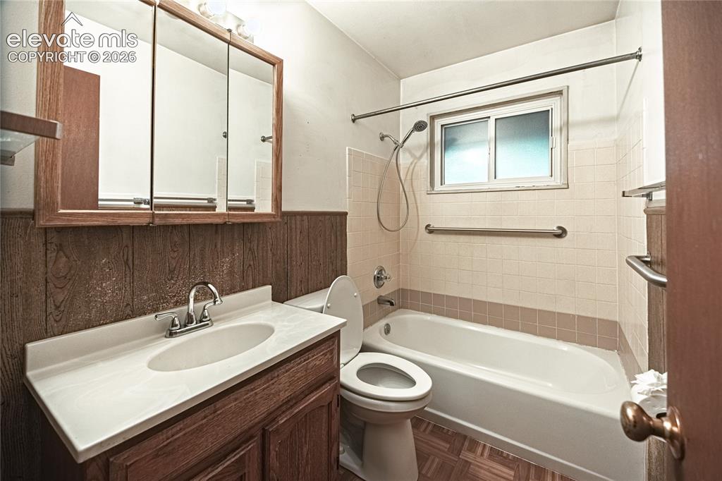 Image 20 of 44: Bathroom featuring a vanity with an integrated sink, tri-fold mirrored medi