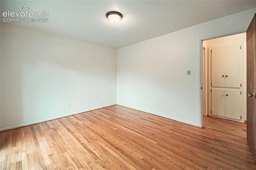 Image 22 of 44: Hardwood flooring, flush-mount ceiling light fixture, and built-in cabinetr