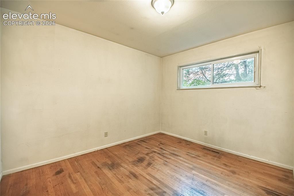 Image 25 of 44: Hardwood flooring, painted walls, single window, and a ceiling-mounted ligh