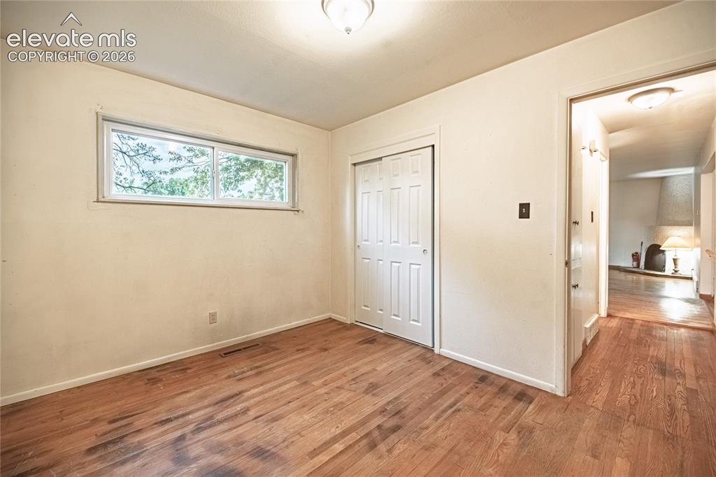 Image 26 of 44: Hardwood flooring throughout, featuring a window with exterior tree views,