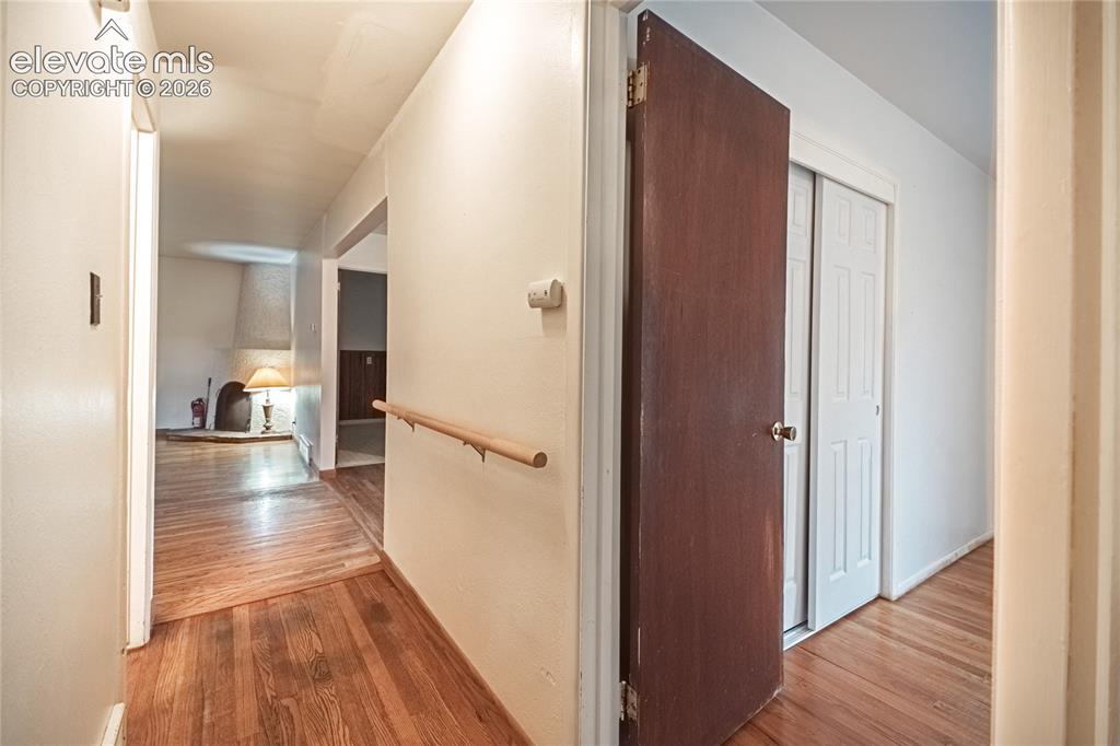 Image 28 of 44: Hardwood flooring throughout, with a light wood-finish handrail