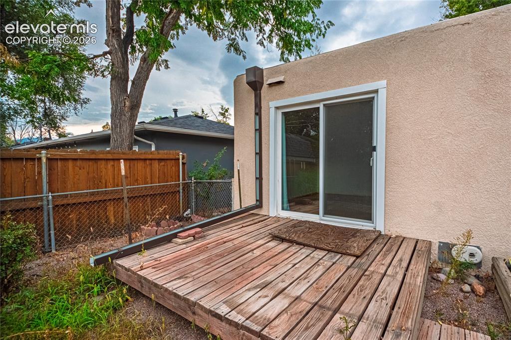 Image 33 of 44: Sliding glass door opening to a wood deck