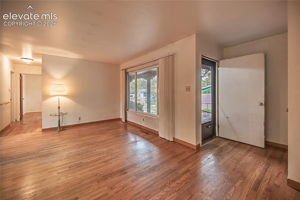 Image 5 of 44: Wood-finish flooring throughout, light-toned wall finishes, and a large bay