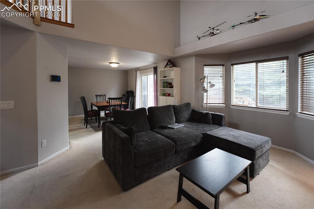 Image 10 of 45: Living area featuring carpeting, multiple windows with horizontal blinds, a