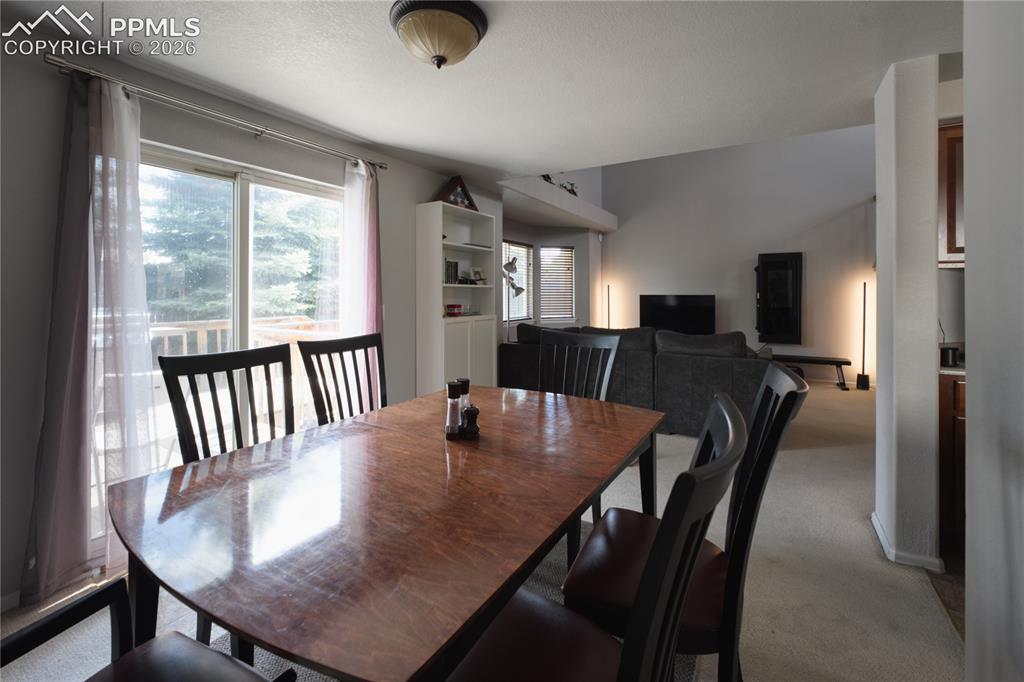 Image 11 of 45: Dining area featuring a sliding glass door with exterior deck access