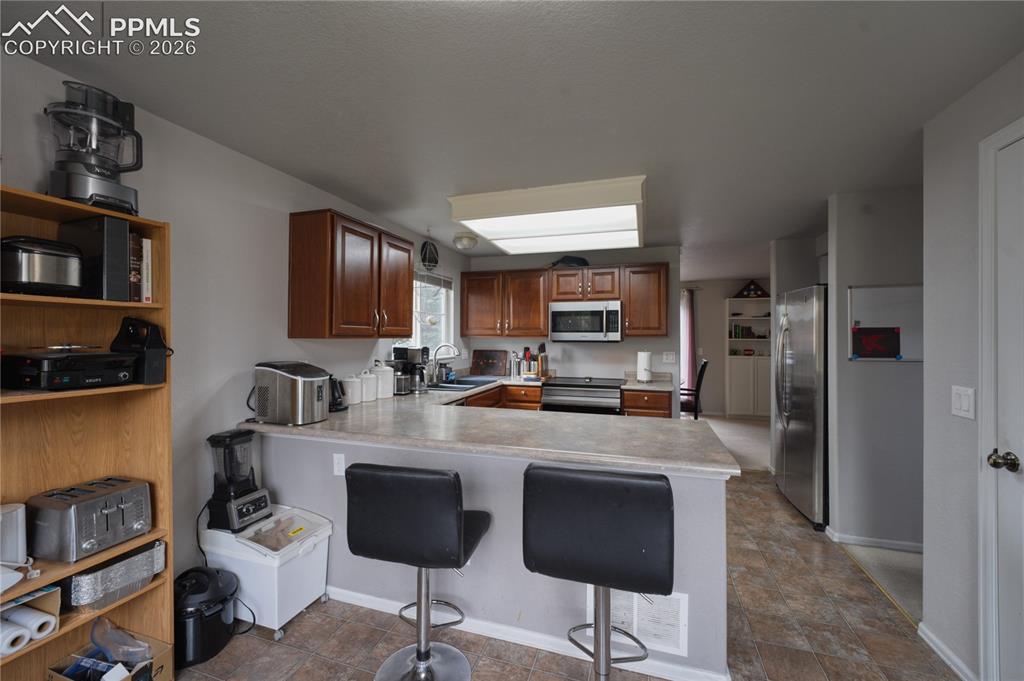 Image 15 of 45: Kitchen featuring wood-finish cabinetry, stainless steel appliances, and a 