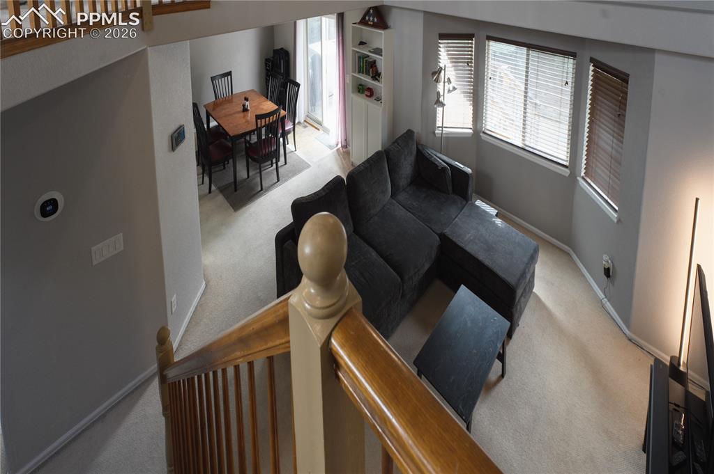 Image 16 of 45: Open-concept living area featuring a bay window with natural wood blinds, c