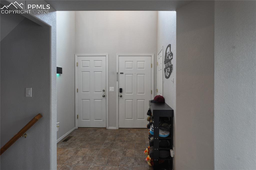 Image 2 of 45: Entryway featuring high ceilings, neutral wall tones, two paneled doors, an