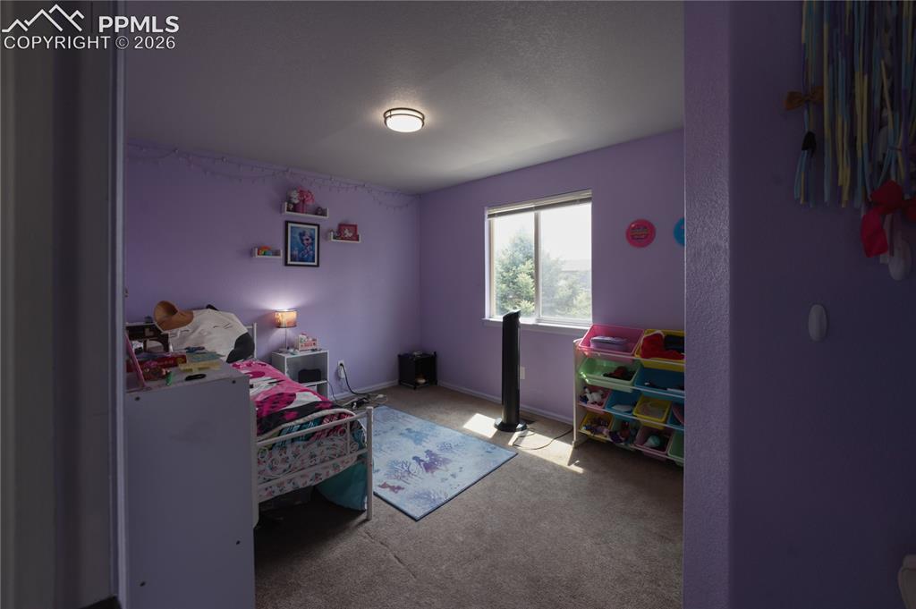 Image 25 of 45: Bedroom featuring a window with natural light, wall-mounted shelving, and a