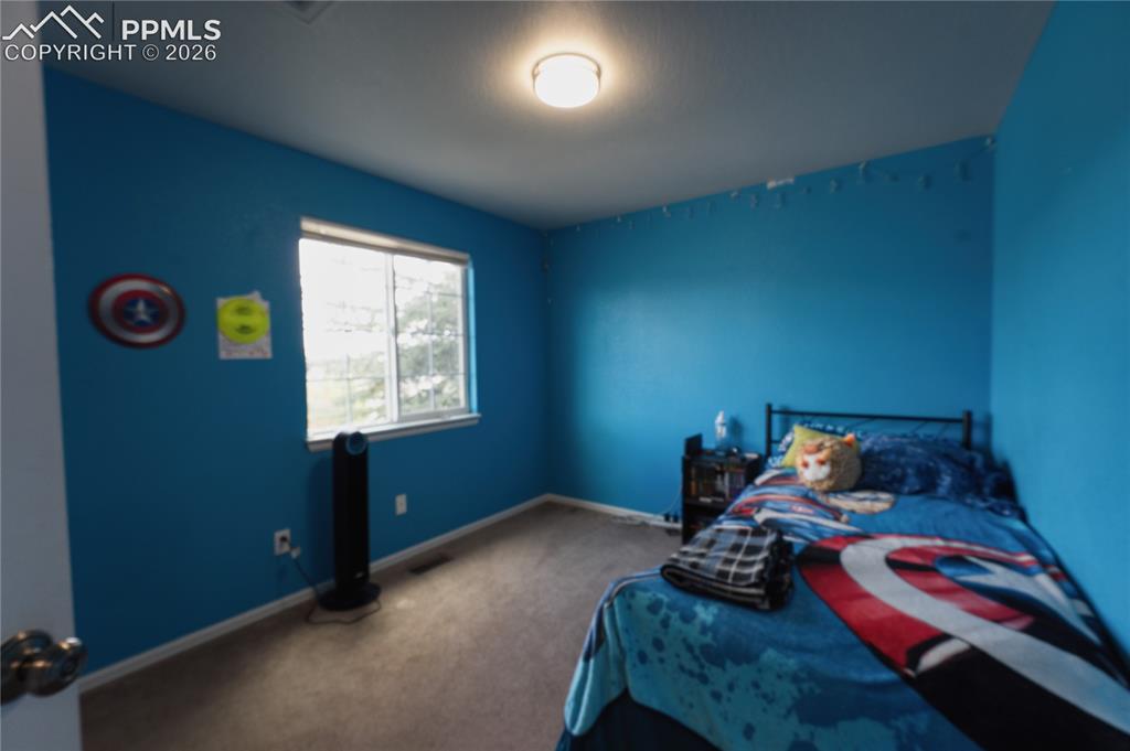 Image 26 of 45: Bright room with blue painted walls and light-colored carpeting