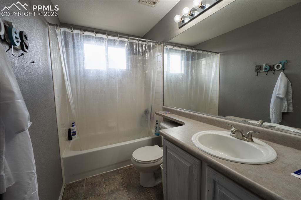 Image 28 of 45: Bathroom featuring a tub/shower combination with two frosted windows, a van