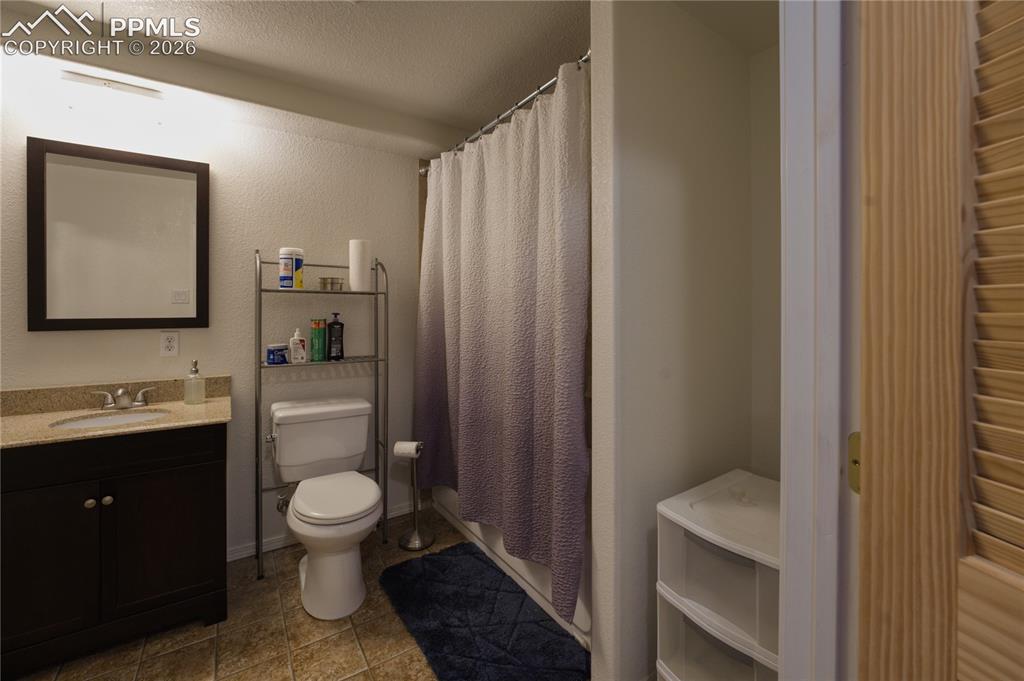 Image 40 of 45: Bathroom featuring a dark wood vanity with a light-toned countertop, a fram